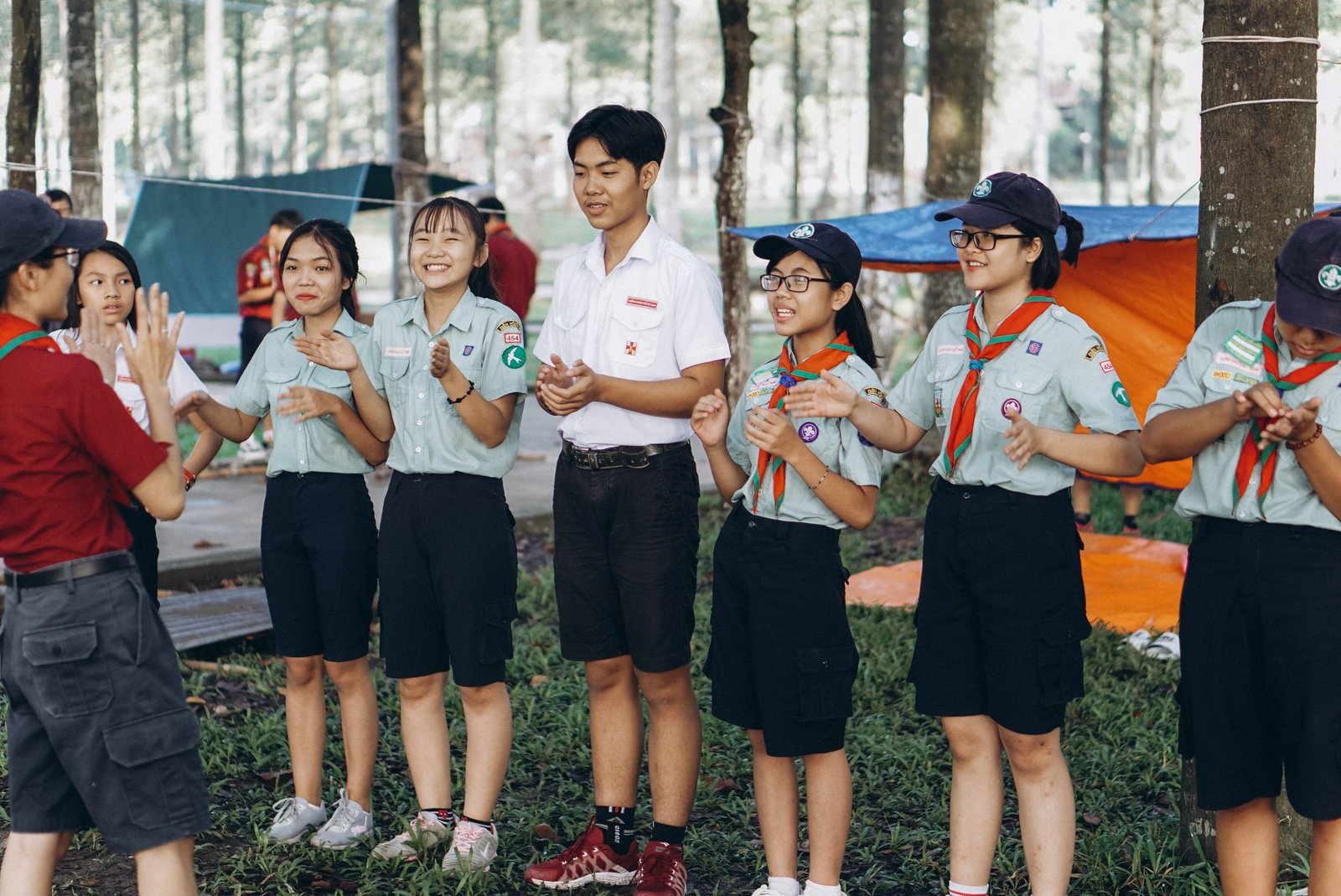 Young scouts participating in teamwork activities outdoors during a summer camp.
