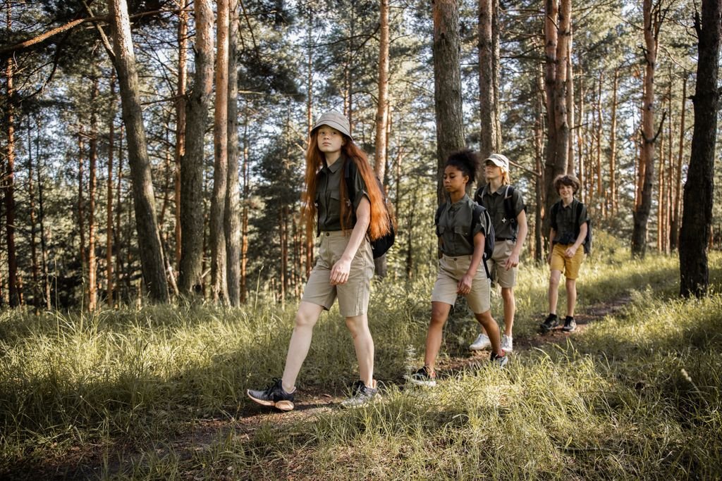 Group of teenagers hiking through a forest trail, enjoying nature and exploration.
