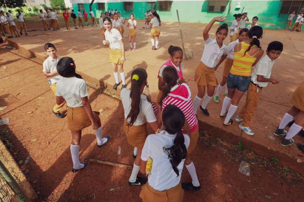 Students in uniforms enjoying outdoor activities in a schoolyard during the day.