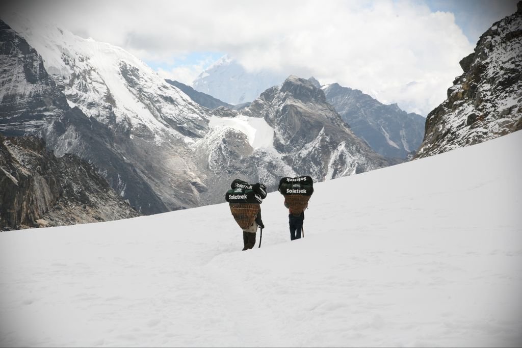 Two trekkers navigating snowy terrain in the majestic Himalayas.